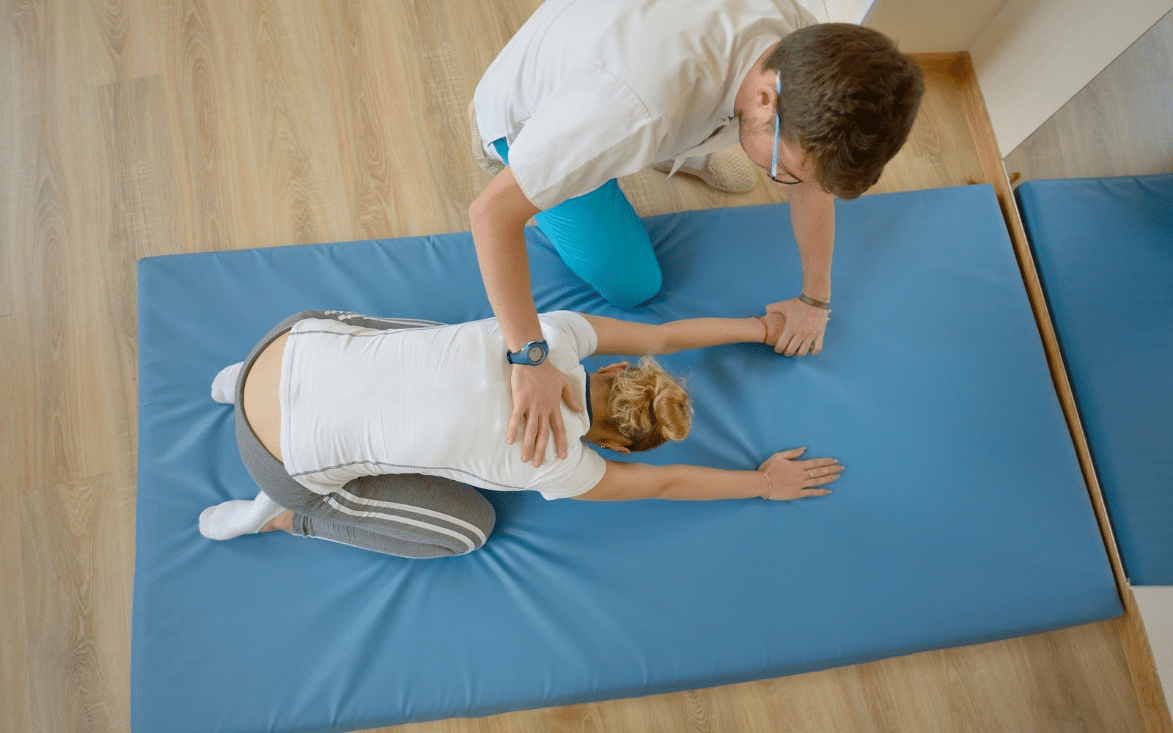 A physical therapist helping a patient stretch.